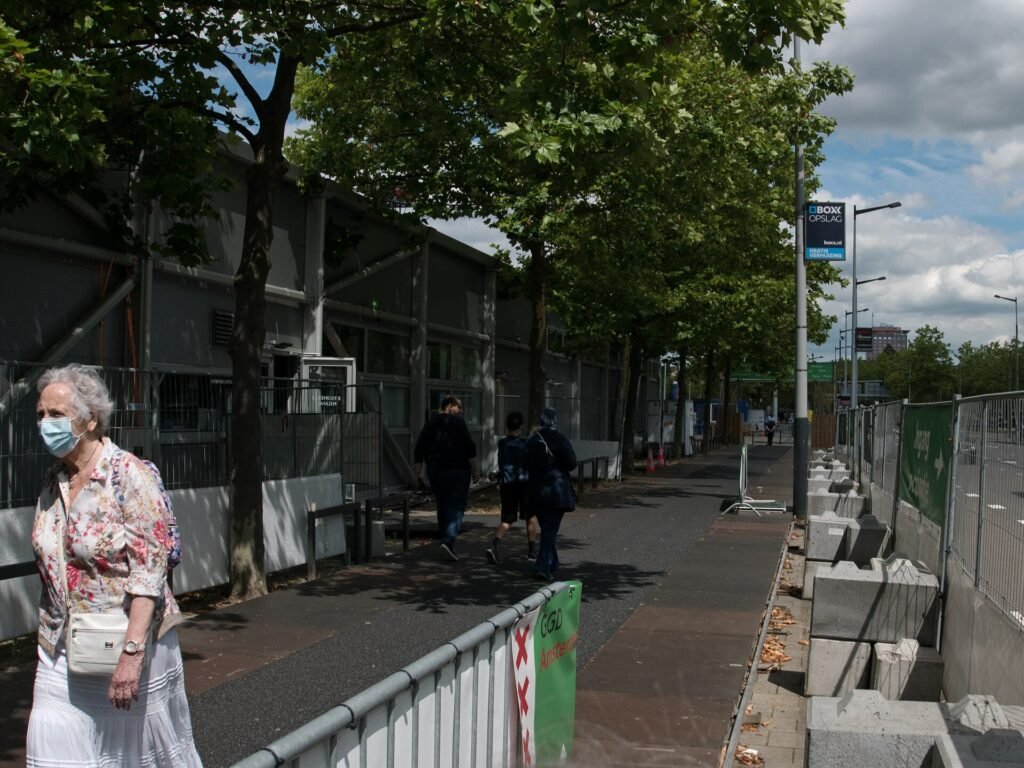 An elderly woman walking along a city sidewalk in Amsterdam, illustrating age-friendly urban design