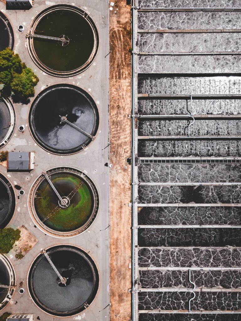 Aerial view of a water treatment plant showing tanks and pipes, representing smart water infrastructure