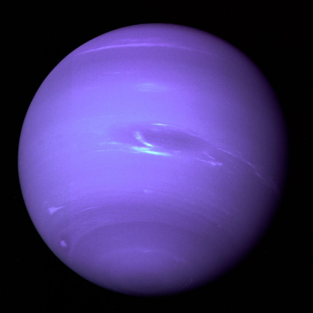 Full-disk photograph of Neptune, deep blue with visible cloud bands, taken by NASA's Voyager 2 spacecraft.