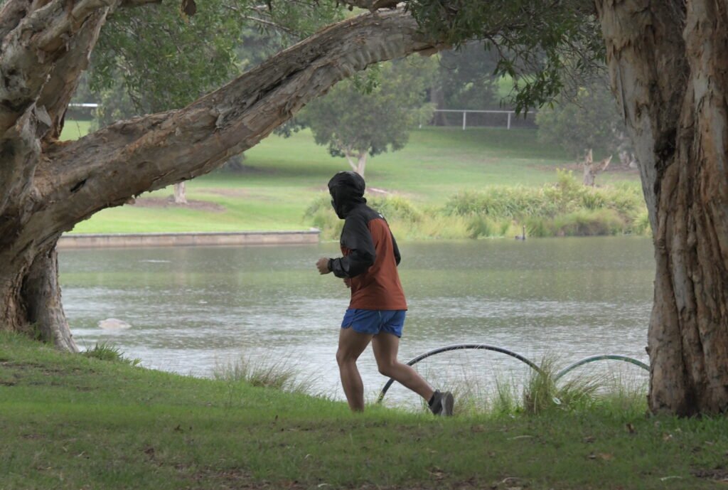 An adult jogging on a park path, illustrating how much exercise adults need each week for aerobic health