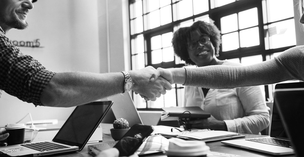 Two business partners shaking hands, representing founders agreeing to become co-founders of a startup