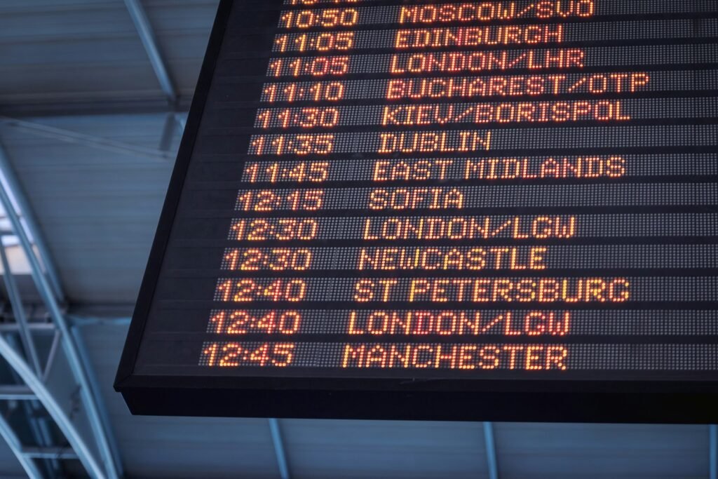 A low-angle view of an airport departure board listing flights