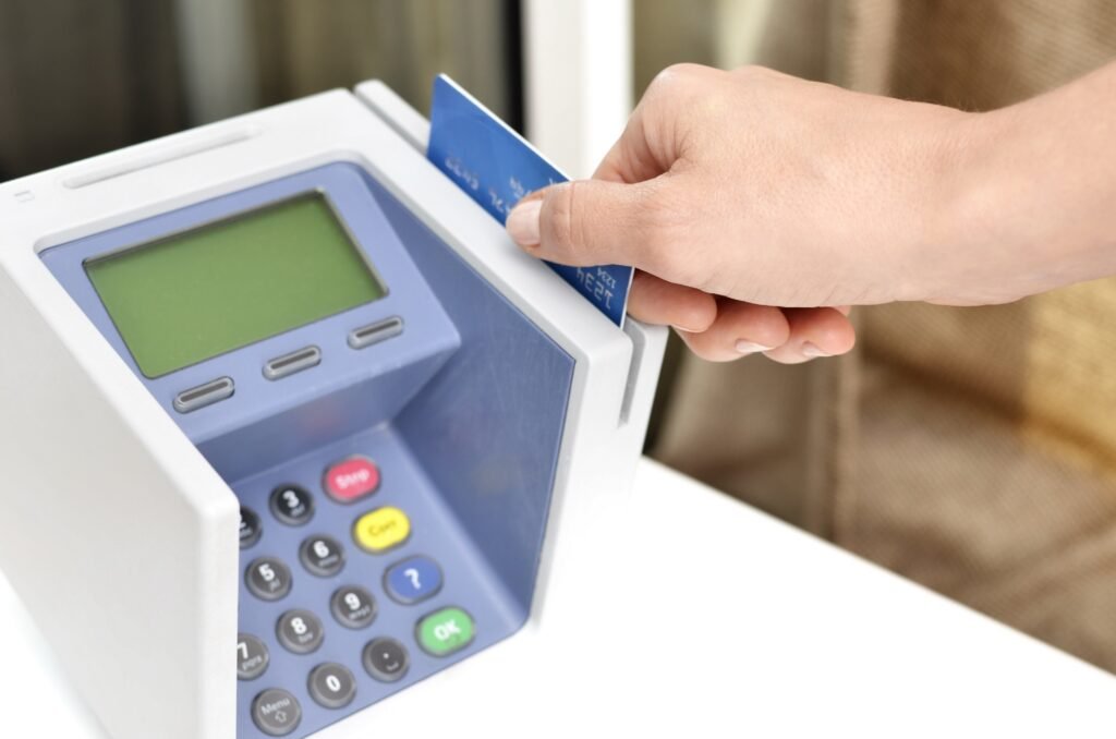 A person paying with a credit card, the kind of everyday borrowing and repayment behavior that credit scoring models track to calculate a credit score.
