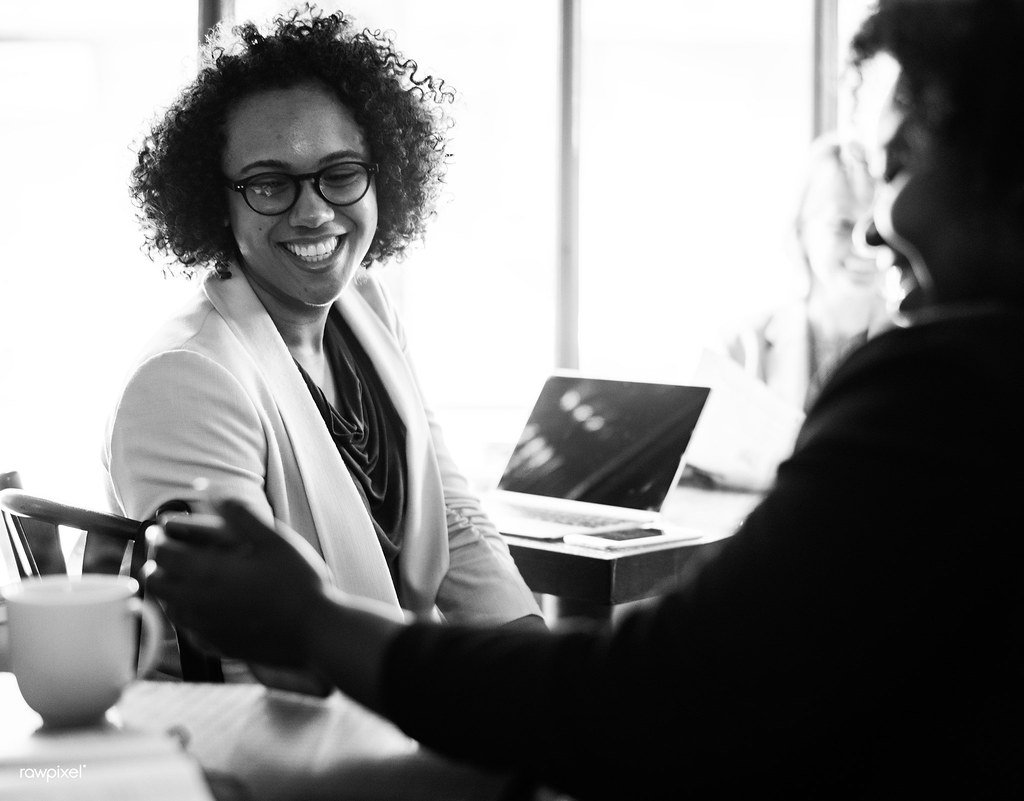 Two entrepreneurs discuss their business plan over coffee at a cafe table.