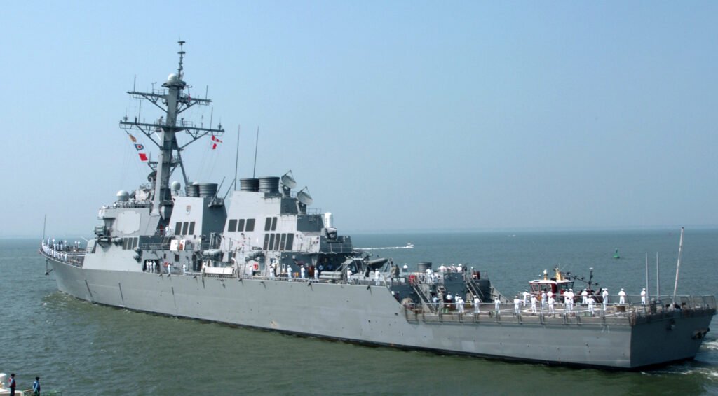 A guided missile destroyer under way at sea, seen from off the starboard bow.