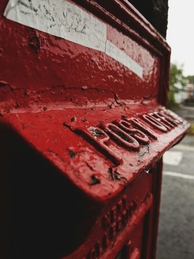A red public post box on a street wall