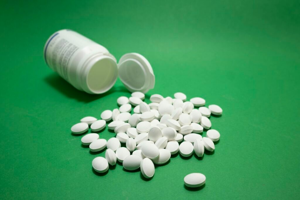 White tablets spilling from an open medicine bottle