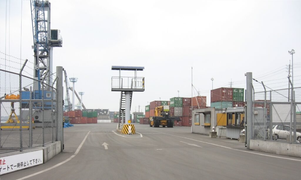 Gantry cranes and stacked shipping containers at a container terminal.