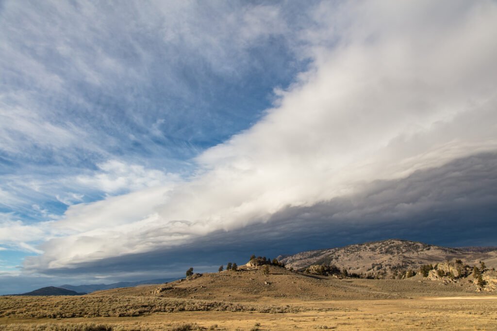 Storm front rolling across a valley, an example of short-term weather rather than long-term climate