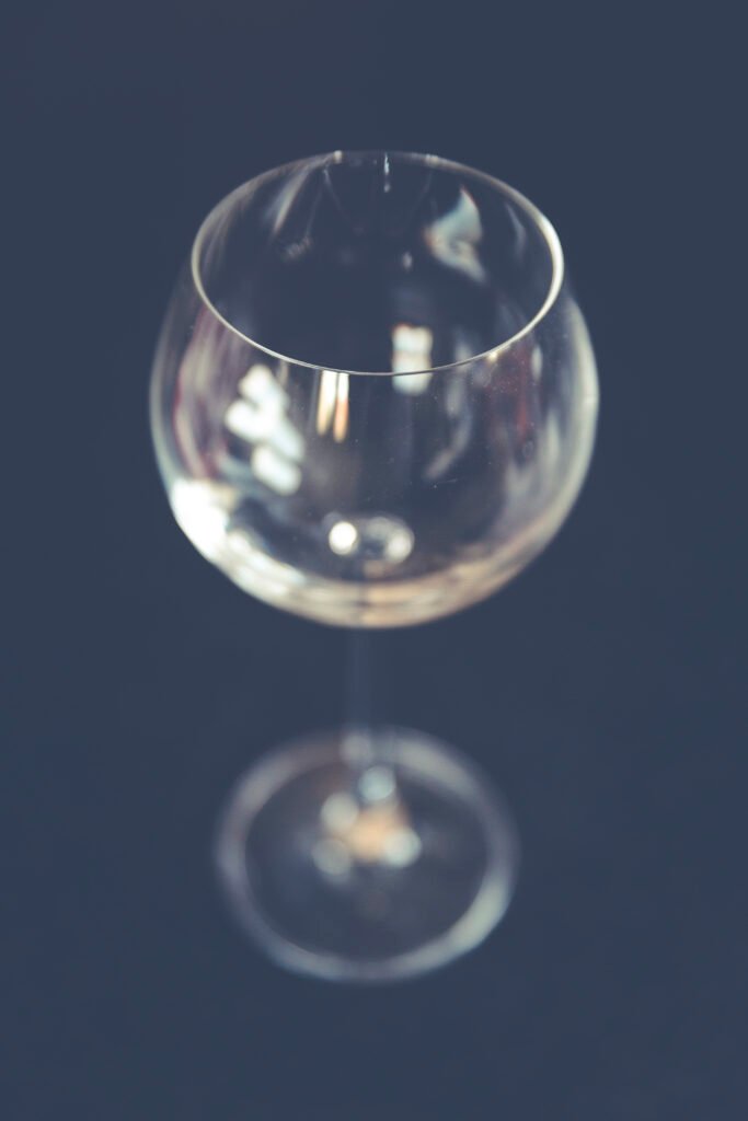 A close-up of a wine glass, representing alcohol consumption that can lead to a hangover.