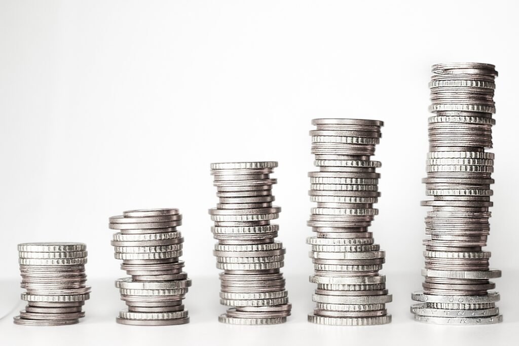 Ascending stacks of coins, illustrating how compound interest causes savings to grow at an accelerating rate over time.