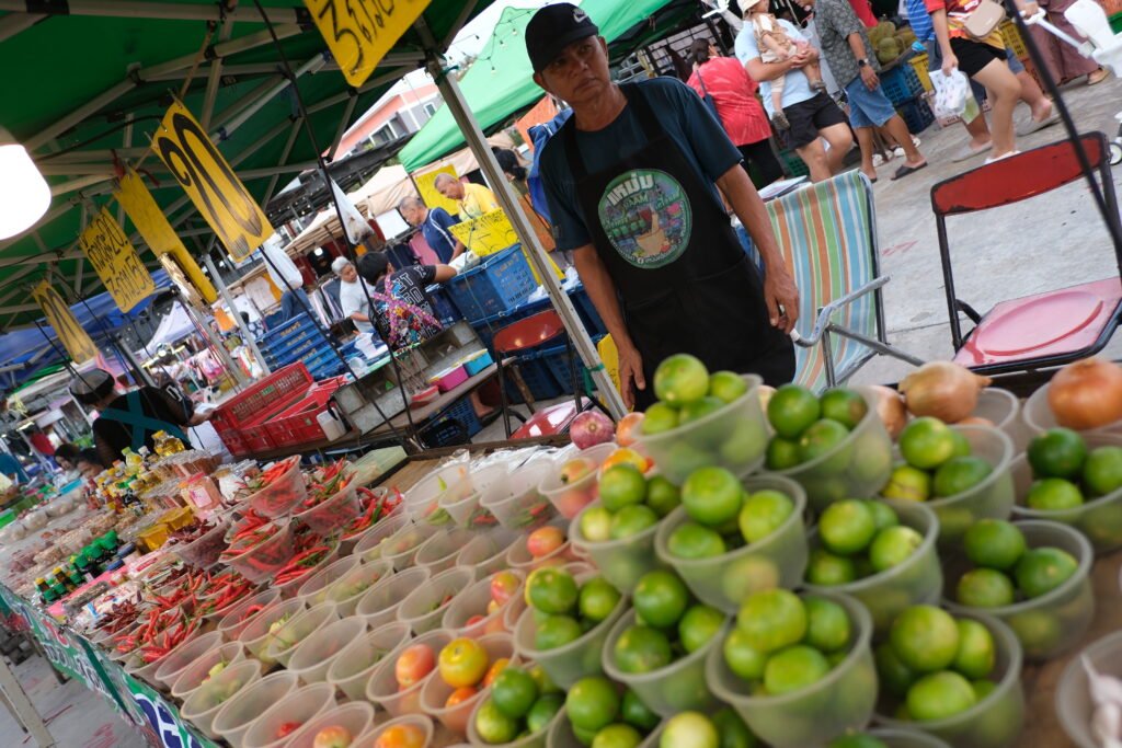 Shoppers browse a produce market stall, an everyday illustration of supply and demand setting prices as buyers and sellers interact.