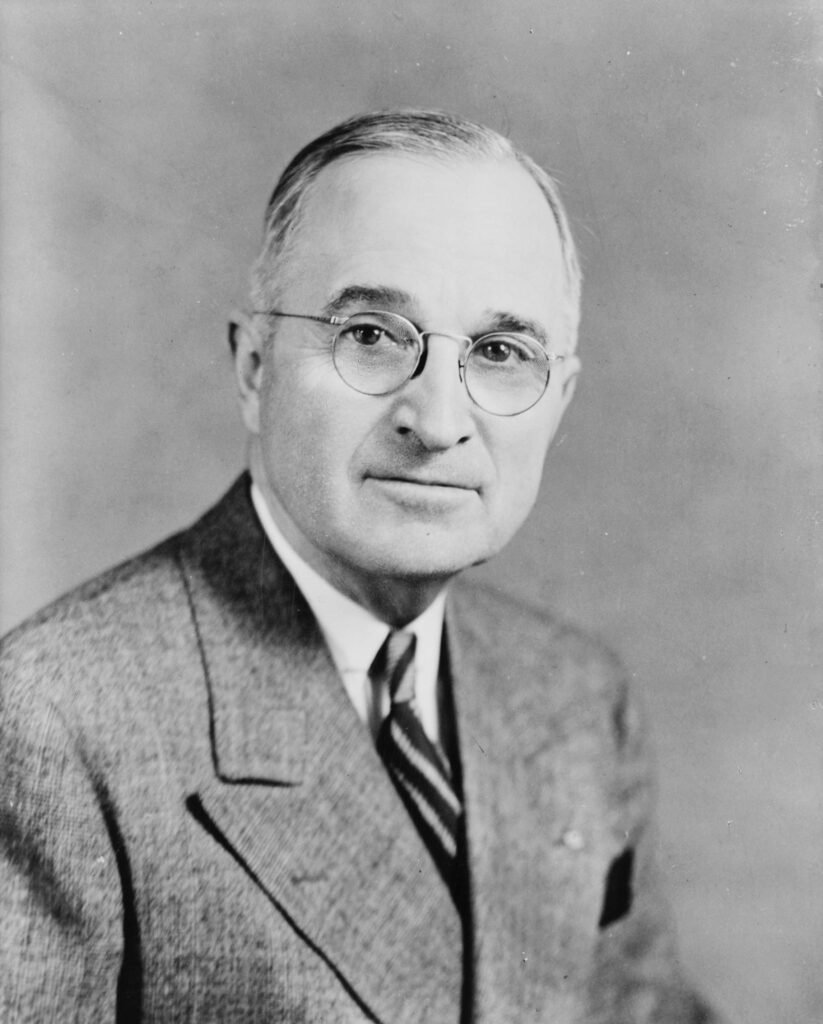 Formal black and white half-length portrait of President Harry S. Truman, facing the camera, taken in 1945.
