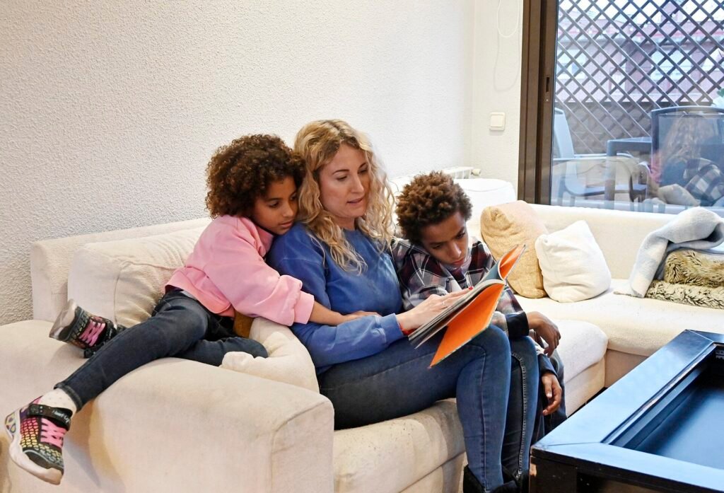 A mother reading a picture book aloud to her two young children